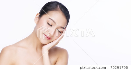 Charming young woman touching her face with clean fresh skin  70291796