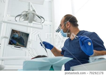 people, medicine, stomatology and health care concept - happy male dentist with woman patient at dental clinic office 70292178