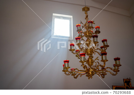 chandelier with candles on the ceiling in Church 70293688