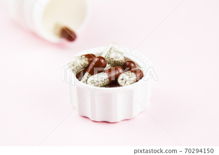 Brown soluble capsules on pink. Herbal drugs. Alternative medicine in capsule Brown soluble capsules on pink. Herbal drugs. Alternative medicine in capsule 70294150