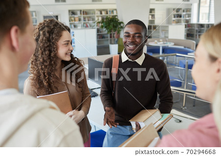 Cheerful Students Talking in College Library 70294668
