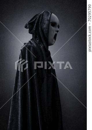 Ghostly figure in hooded cloak in the dark 70295790