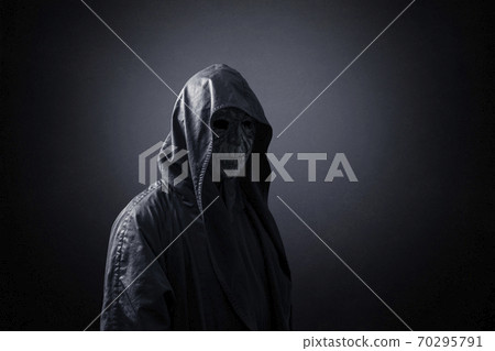 Ghostly figure in hooded cloak in the dark 70295791