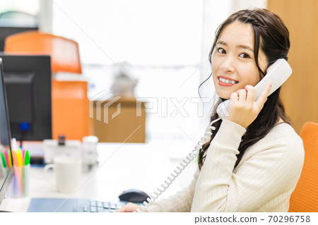 一邊看著電腦屏幕一邊通過電話接到訂單的女人 70296758