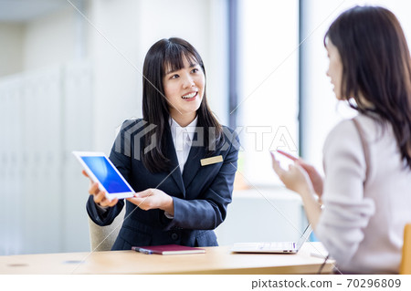 在接待處與一名婦女穿著西裝諮詢的形象 70296809
