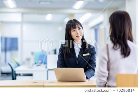 在接待處與一名婦女穿著西裝諮詢的形象 70296814