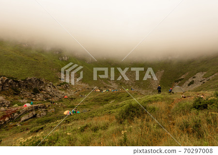 Morning rain and fog near a mountain lake, Carpathian lake Brebeneskul, a tent camp in the fog. 70297008