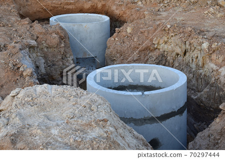 Laying concrete manholes and heating drain pipes and for stormwater system at construction site. 70297444