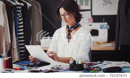 Designer sitting table looking paper Designer sitting table looking paper 70297633