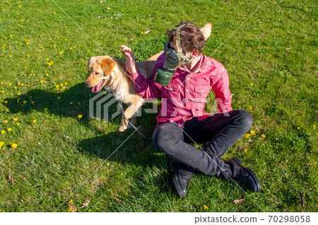 boy wearing old style virus mask   with his dog playing at garden 70298058
