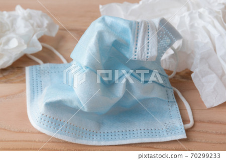 Wrinkled disposable face masks close up next to disposable tissues Wrinkled disposable face masks close up next to disposable tissues 70299233