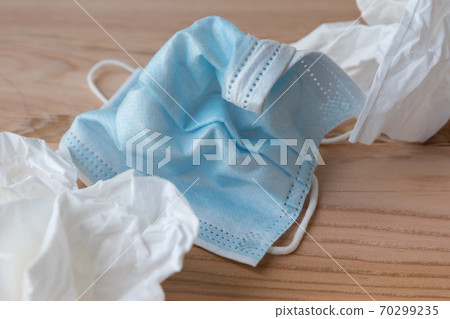 Wrinkled disposable face masks close up next to disposable tissues Wrinkled disposable face masks close up next to disposable tissues 70299235