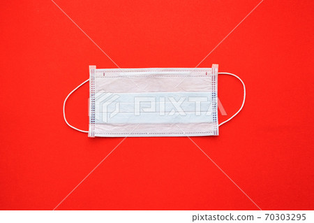 disposable medical mask on a red background. disposable medical mask on a red background. 70303295