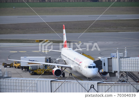 An airplane connecting a boarding bridge and waiting for departure An airplane connecting a boarding bridge and waiting for departure 70304039