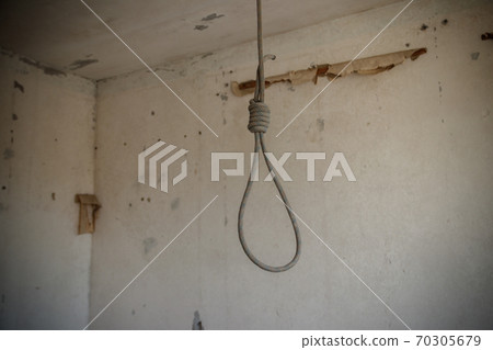 Deadly loop hanging from the ceiling in abandoned apartment. Concept of suicide, despair Deadly loop hanging from the ceiling in abandoned apartment. Concept of suicide, despair 70305679