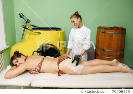 Woman getting cryolipolysis fat treatment on hip in beauty salon Woman getting cryolipolysis fat treatment on hip in beauty salon 70306139