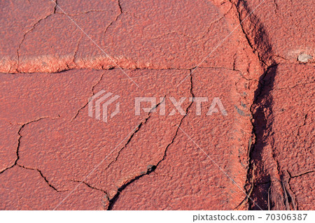 Texture of red wet ground polluted with iron ore waste 70306387