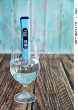 TDS meter in glass to determine quality of water. TDS meter in glass to determine quality of water. 70306495