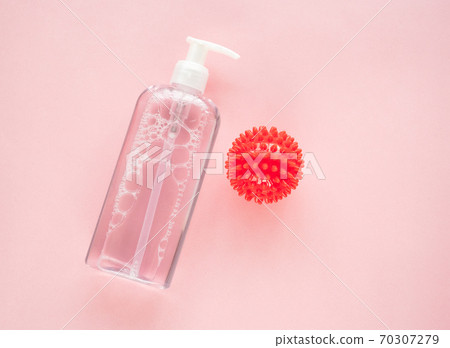 bottle of antiseptic and model COVID-19 on pink. bottle of antiseptic and model COVID-19 on pink. 70307279