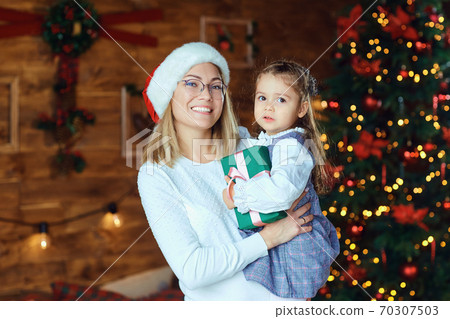 Mom with her daughter with gifts at Christmas. Mom with her daughter with gifts at Christmas. 70307503