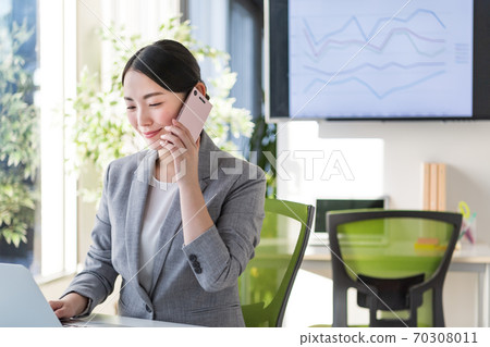 Business woman working in an office by a bright window 70308011