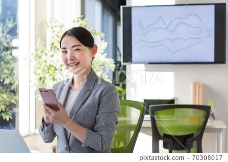 Business woman working in an office by a bright window 70308017