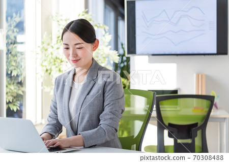 Business woman working in an office by a bright window 70308488