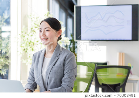 Business woman working in an office by a bright window 70308491