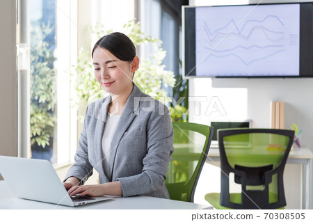 Business woman working in an office by a bright window 70308505