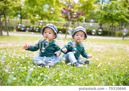 Twins playing with soap bubbles 70310666