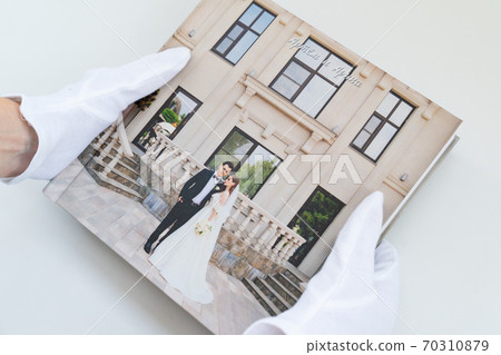 hands in white gloves holding a photo book hands in white gloves holding a photo book 70310879