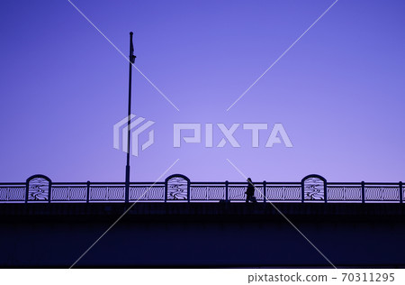 People walking on the bridge at sunset 70311295