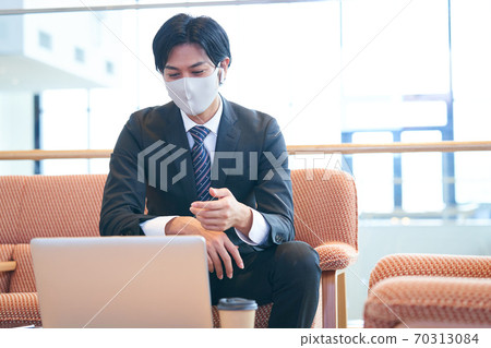 Young businessman sitting on the sofa and having an online meeting 70313084