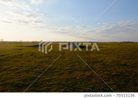 Hill in the field. Yellowed grass. Evening sky over the field. Hill in the field. Yellowed grass. Evening sky over the field. 70313136