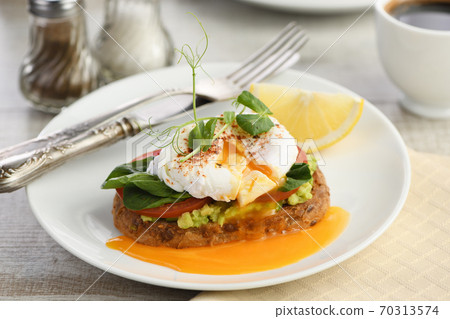 Eggs Benedict with guacamole on cereal bread Eggs Benedict with guacamole on cereal bread 70313574