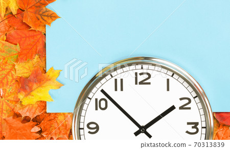 Plain wall clock in the center on red fall foliage Plain wall clock in the center on red fall foliage 70313839