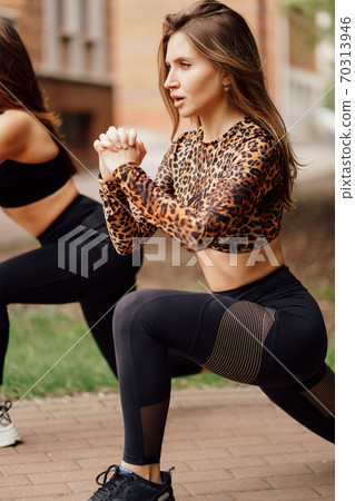 girls athletes in sports apparel, doing lunges girls athletes in sports apparel, doing lunges 70313946