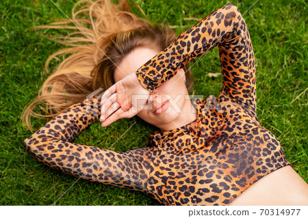 girl athlete is resting on the lawn after workout. 70314977