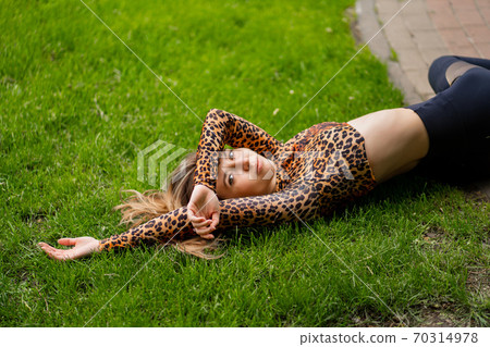 girl athlete is resting on the lawn after workout. girl athlete is resting on the lawn after workout. 70314978