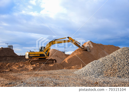 Excavator working at construction site. Excavator working at construction site. 70315104
