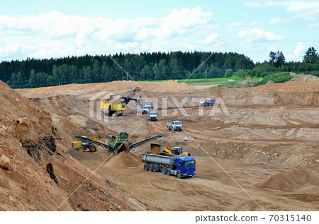 Wheel front-end loader loads sand into a dump truck.  70315140