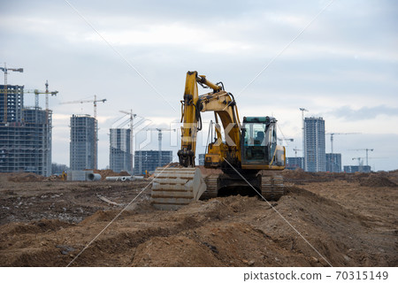 Excavators at earthworks on construction site.  70315149