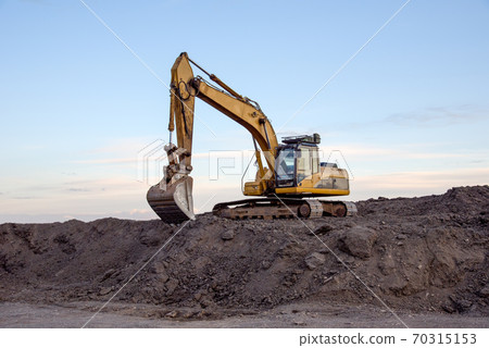 Excavator working at open pit mining on sunset background.  70315153
