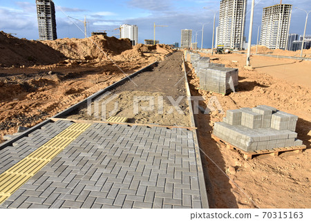 Laying paving slabs at construction site. Laying paving slabs at construction site. 70315163