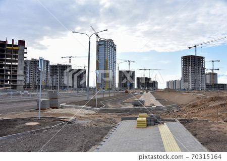 Laying paving slabs at construction site. Process of installing paving bricks in the town  70315164