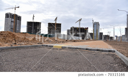 Laying paving slabs at construction site. Process of installing paving bricks in the town pedestrian zone. 70315166