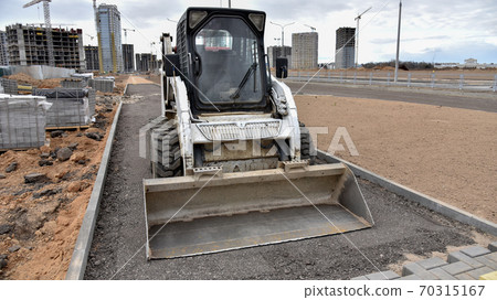 Bobcat skid-steer loader for loading and unloading works on city streets.  70315167