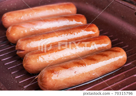 Juicy sausages roasted on the grill pan. Close up. 70315796