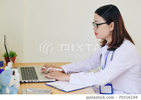 Physician working on laptop 70316194