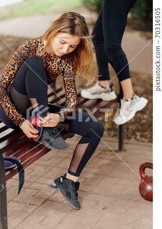 girl in sports apparel wears weights on feet 70316505